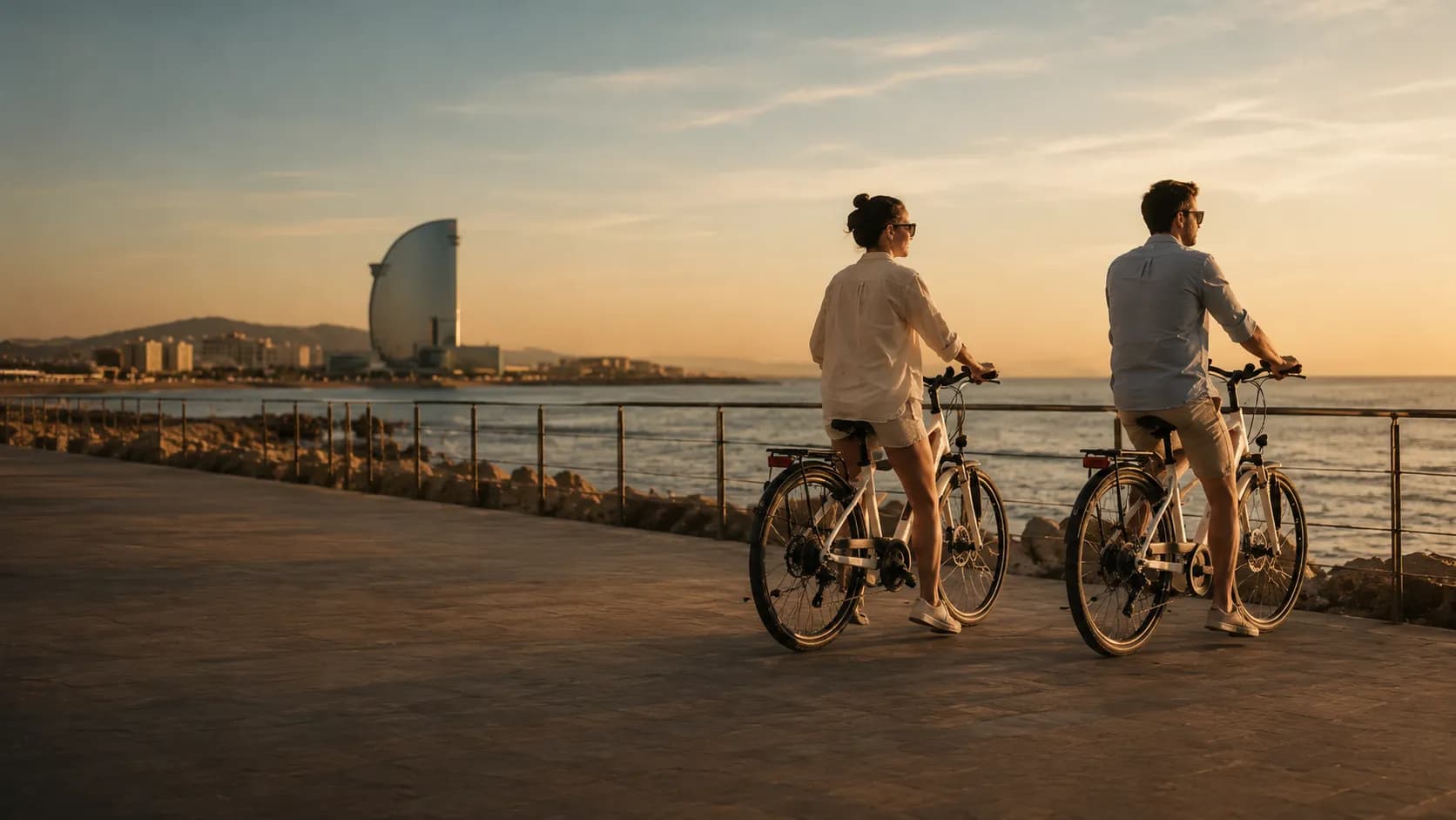 A couple riding e-bikes along the Barcelona seafront on a private Ride BCN tour.